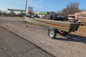 2025 Tracker Grizzly 15 Jon boat on trailer near rural gas station.