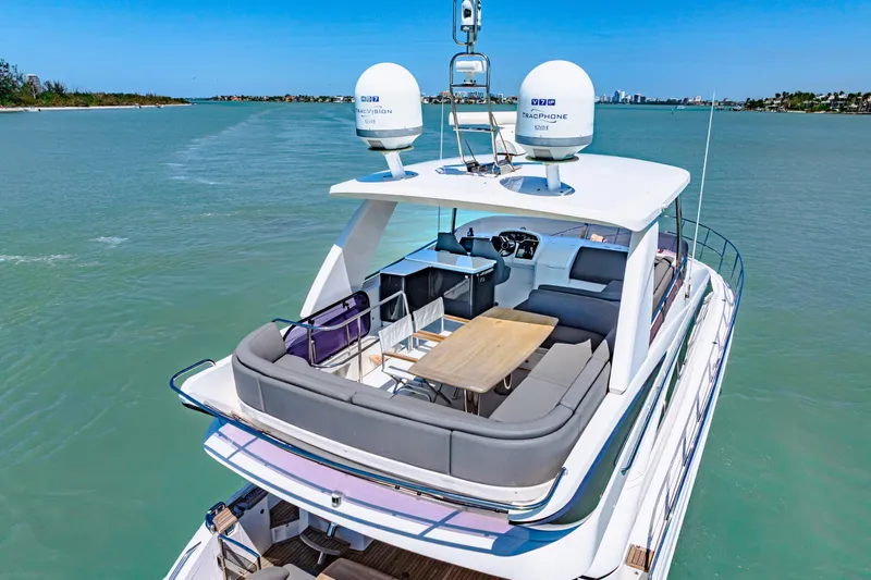 Fuelish Pleasure II Yacht Photos Pics Luxurious 2017 Princess 56 yacht with spacious deck and seating area on calm waters.