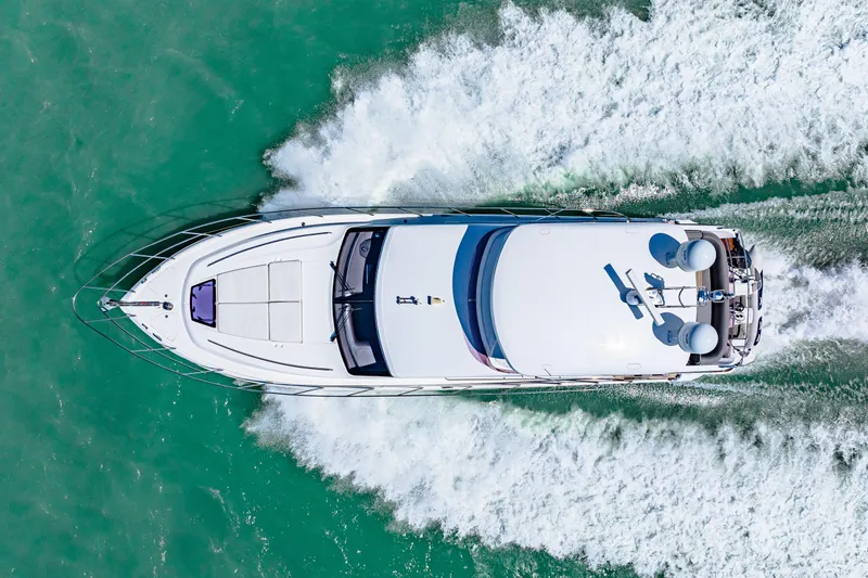 Fuelish Pleasure II Yacht Photos Pics Aerial view of 2017 Princess 56 yacht cruising on turquoise water.
