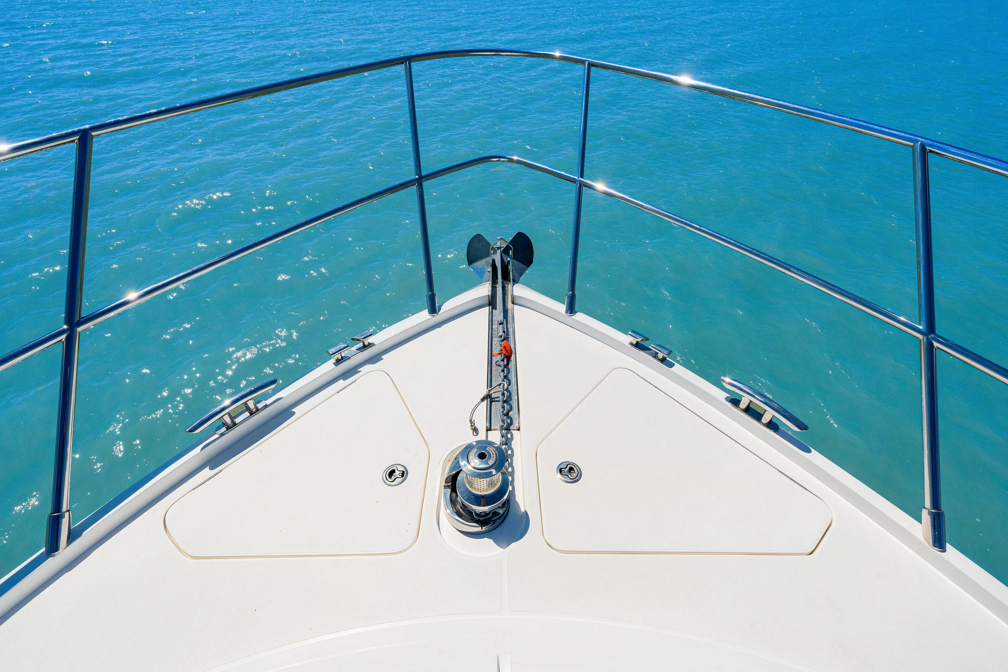 Fuelish Pleasure II Yacht Photos Pics Bow of a 2017 Princess 56 yacht on clear blue water.