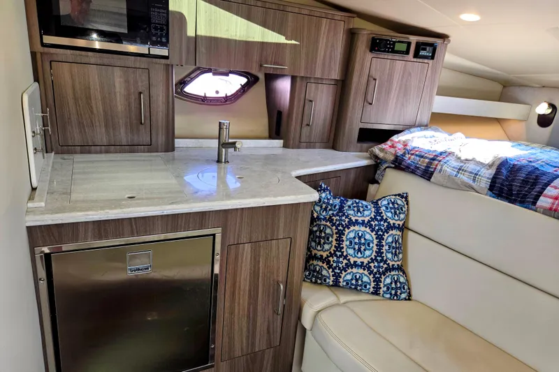 Willowbender Yacht Photos Pics 2019 Regal 35 Sport Coupe interior with kitchenette, seating, and bedding.