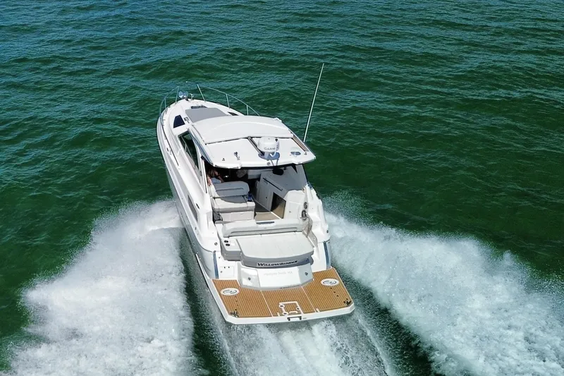 Willowbender Yacht Photos Pics 2019 Regal 35 Sport Coupe cruising on open water, rear view.