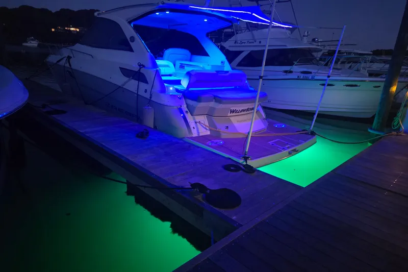 Willowbender Yacht Photos Pics 2019 Regal 35 Sport Coupe with vibrant blue and green LED lights at a dock.