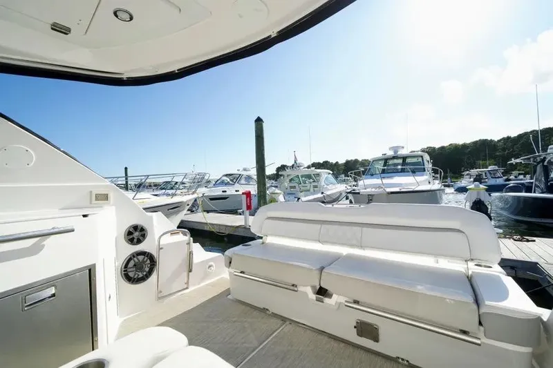 Willowbender Yacht Photos Pics 2019 Regal 35 Sport Coupe interior with marina view, featuring white seating and modern amenities.