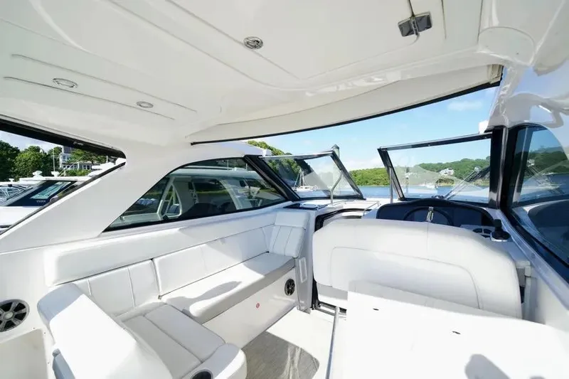 Willowbender Yacht Photos Pics 2019 Regal 35 Sport Coupe interior with white seating and open windows on a sunny day.