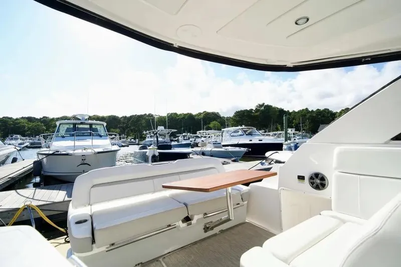 Willowbender Yacht Photos Pics 2019 Regal 35 Sport Coupe interior with marina view, featuring seating and table.