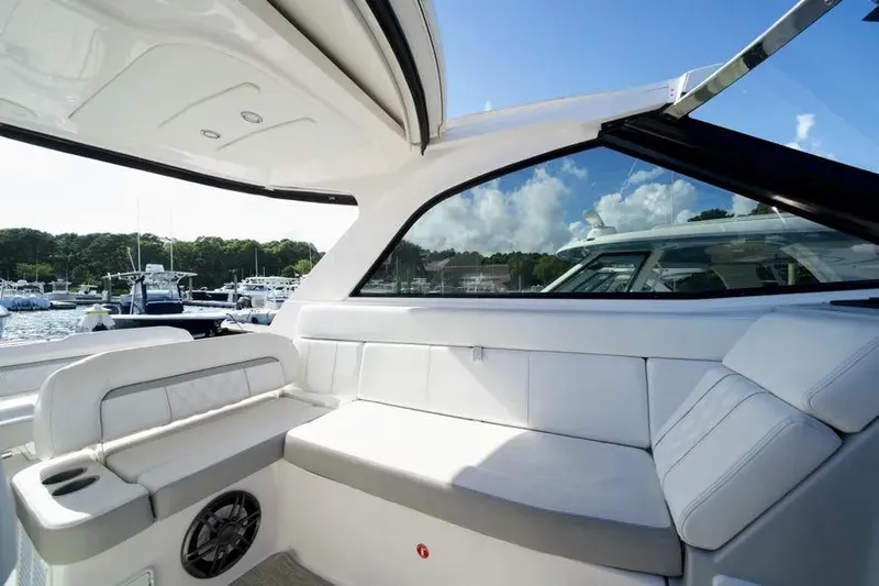 Willowbender Yacht Photos Pics Interior of 2019 Regal 35 Sport Coupe yacht with white seating and open roof.