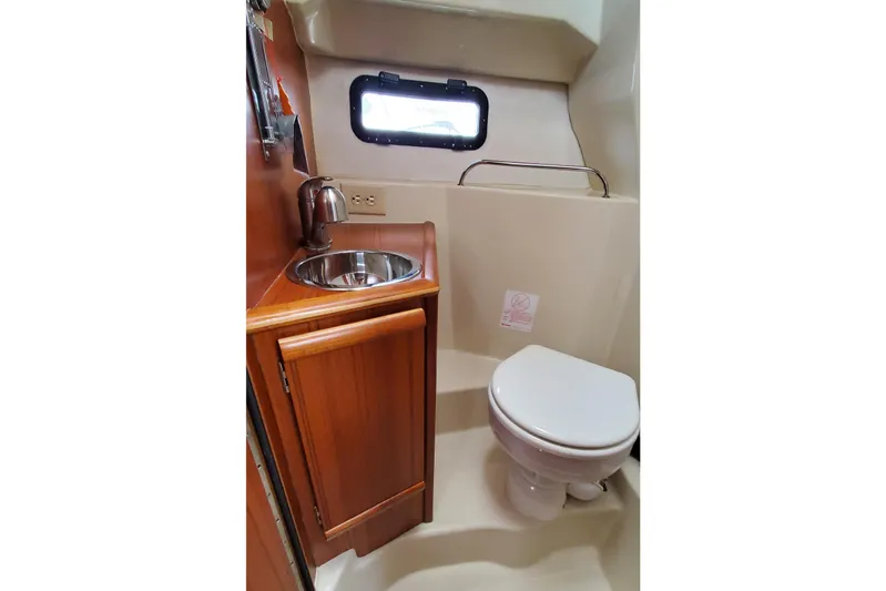 Swell Life Yacht Photos Pics 2021 Ranger Tugs R-25 bathroom with sink, toilet, and porthole window.