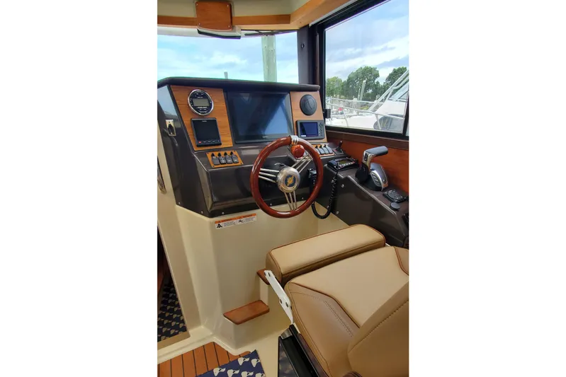 Swell Life Yacht Photos Pics Interior helm of 2021 Ranger Tugs R-25 with modern controls and leather seating.