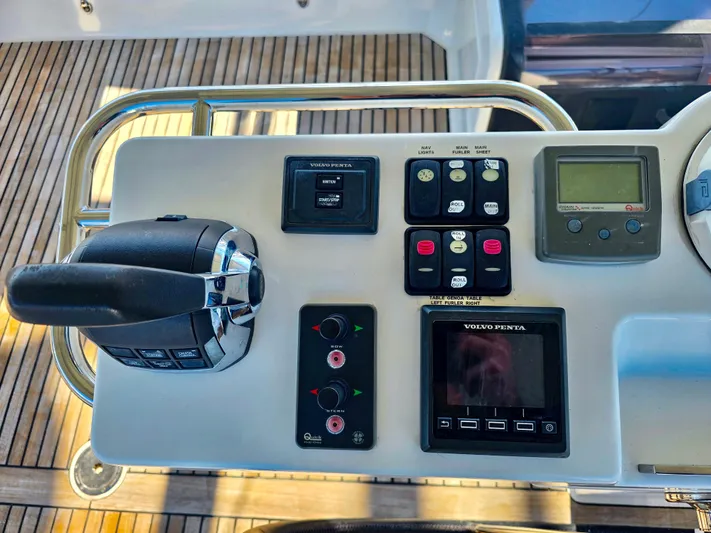 Trois Vignes Yacht Photos Pics Control panel of a 2015 Jeanneau Aft Cockpit boat with various instruments and controls.
