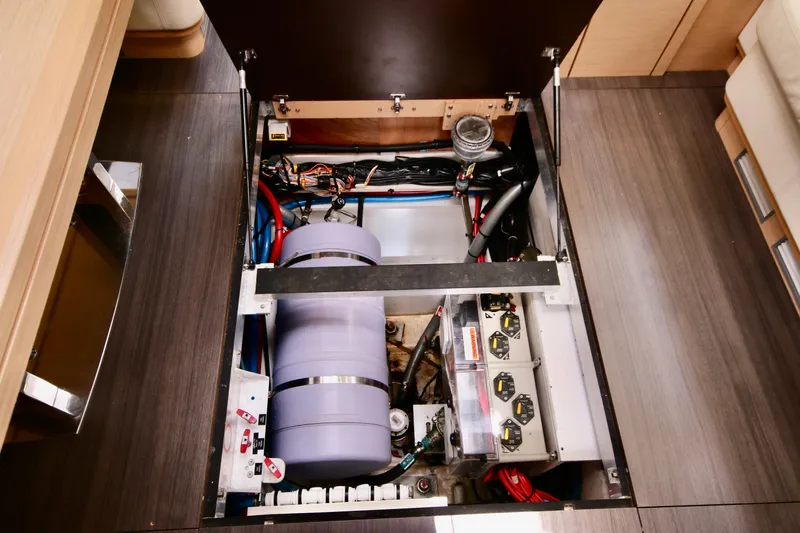 Trois Vignes Yacht Photos Pics Engine compartment of 2015 Jeanneau Aft Cockpit boat, showcasing mechanical components and wiring.