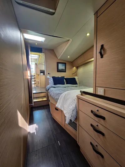 Trois Vignes Yacht Photos Pics Interior of 2015 Jeanneau Aft Cockpit yacht, featuring a cozy bedroom with modern wood finishes.