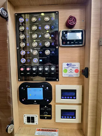Trois Vignes Yacht Photos Pics Control panel of a 2015 Jeanneau Aft Cockpit boat with various switches and displays.