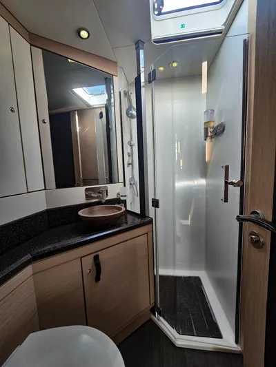 Trois Vignes Yacht Photos Pics 2015 Jeanneau Aft Cockpit bathroom with modern shower and wooden cabinetry.