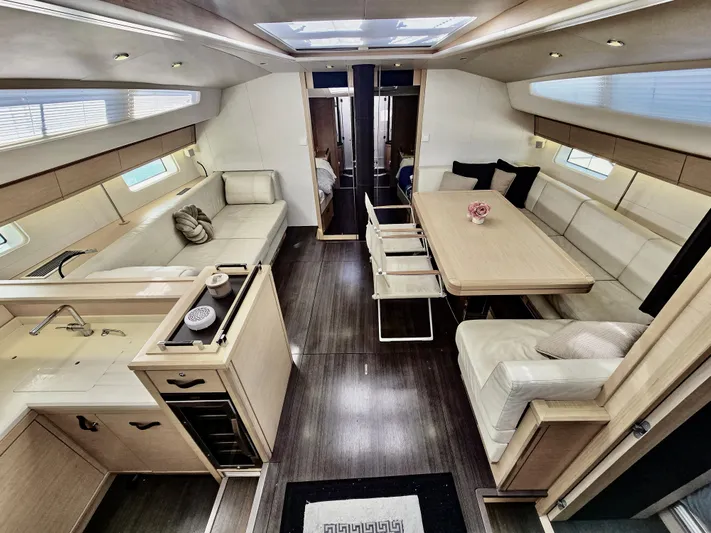 Trois Vignes Yacht Photos Pics Luxurious interior of 2015 Jeanneau Aft Cockpit yacht with modern seating and dining area.