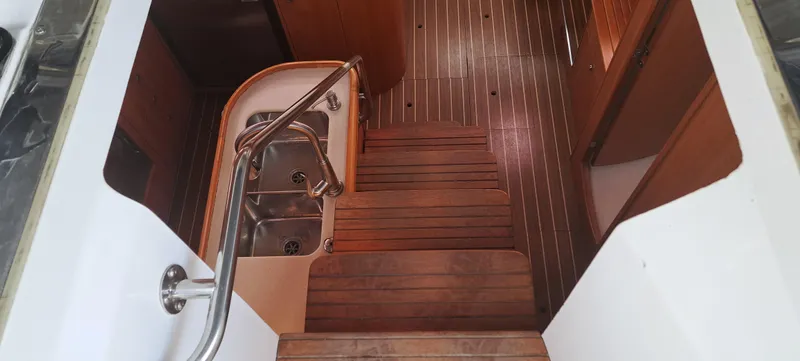 Bashful Yacht Photos Pics Interior stairs and kitchen area of 2006 Hunter 46 LE sailboat with wooden flooring.