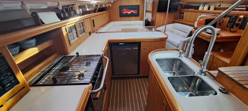Bashful Yacht Photos Pics 2006 Hunter 46 LE yacht interior with modern kitchen, double sink, stove, and cozy seating area.