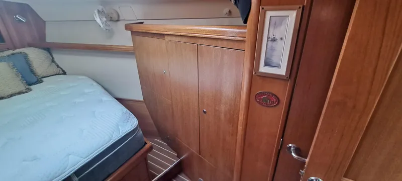 Bashful Yacht Photos Pics Interior cabin of 2006 Hunter 46 LE sailboat with wooden cabinetry and bed.