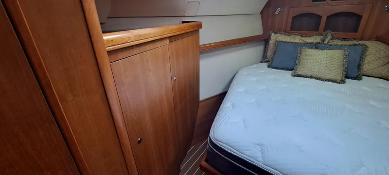Bashful Yacht Photos Pics Interior cabin of 2006 Hunter 46 LE yacht with bed and wooden cabinetry.