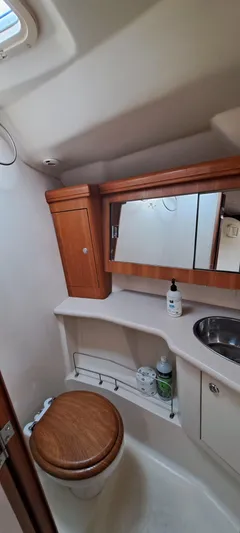 Bashful Yacht Photos Pics 2006 Hunter 46 LE yacht bathroom with wooden cabinetry and stainless steel sink.