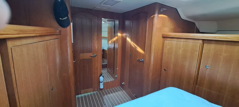Bashful Yacht Photos Pics Interior cabin of 2006 Hunter 46 LE sailboat with wooden cabinetry and mirrored door.