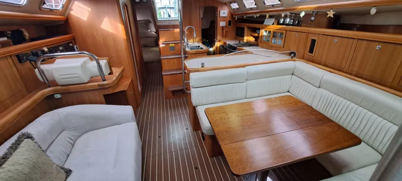 Bashful Yacht Photos Pics Interior of a 2006 Hunter 46 LE sailboat with wood finishes and white seating.