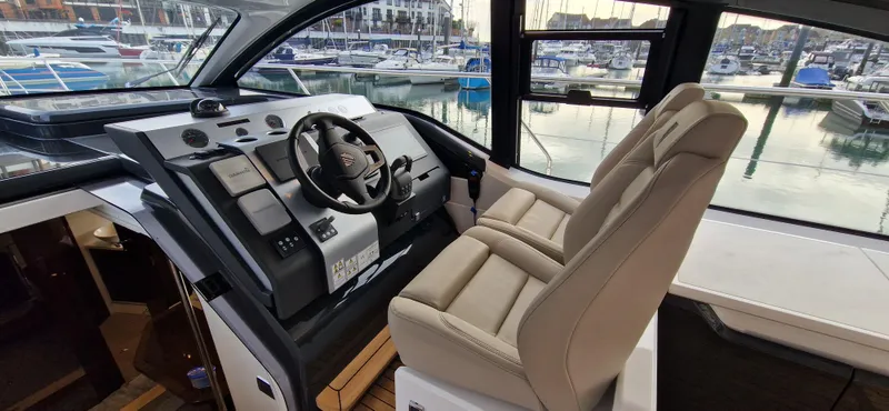 In Stock Yacht Photos Pics 2025 Fairline Targa 45 Open cockpit with modern controls and luxurious seating at marina.