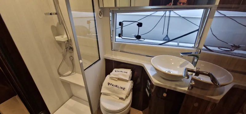 In Stock Yacht Photos Pics Bathroom interior of 2025 Fairline Targa 45 Open yacht, featuring modern fixtures and branded towels.