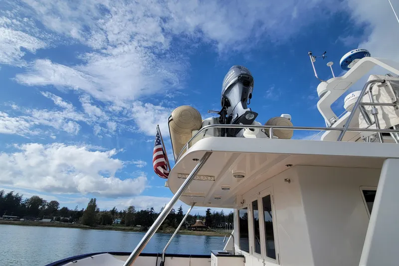 Fellowship Yacht Photos Pics 2001 Grand Alaskan Pilothouse yacht with American flag, under a bright blue sky.