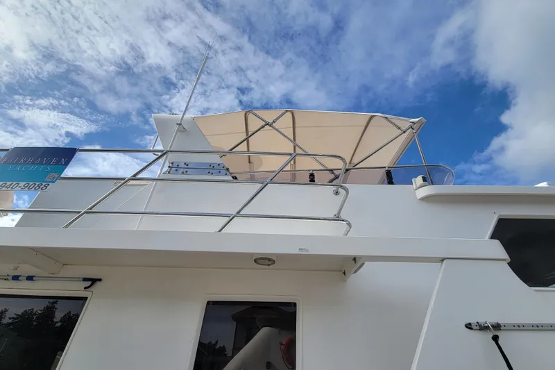 Fellowship Yacht Photos Pics 2001 Grand Alaskan Pilothouse yacht with canopy, blue sky background.