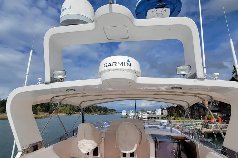 Fellowship Yacht Photos Pics 2001 Grand Alaskan Pilothouse boat with Garmin equipment, docked in a scenic marina.