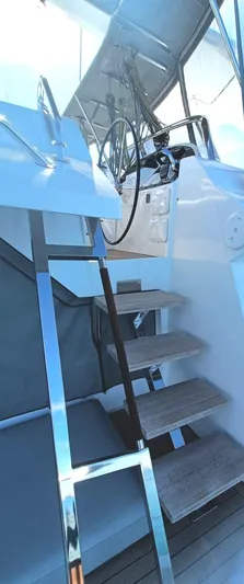 Feel So Good Yacht Photos Pics Staircase leading to helm on 2021 Privilege 640 yacht, featuring modern design and steering wheel.