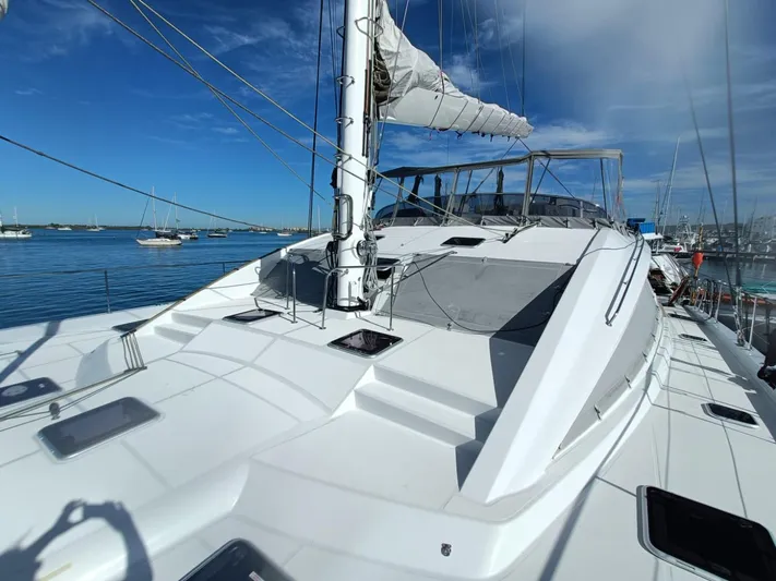 Feel So Good Yacht Photos Pics Luxury Privilege 640 catamaran, 2021 model, docked in a serene marina under clear blue skies.