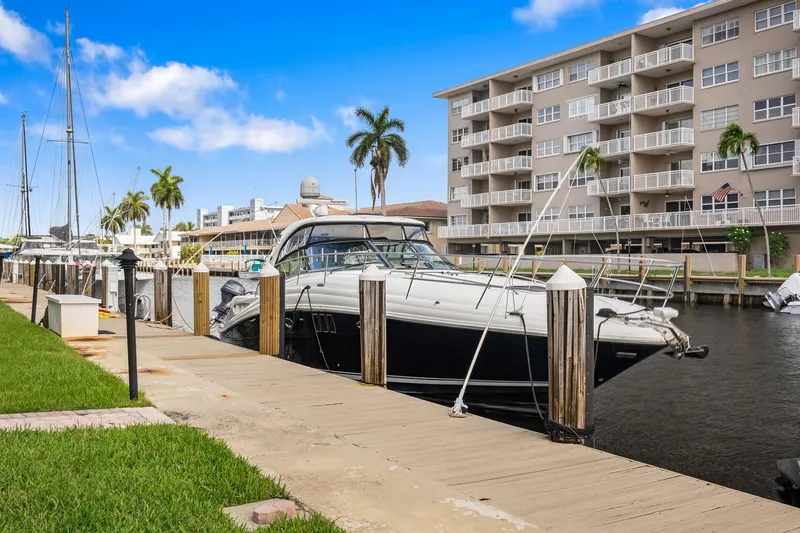  Yacht Photos Pics 2008 Sea Ray 44 Sundancer docked near waterfront apartments, under a clear blue sky.