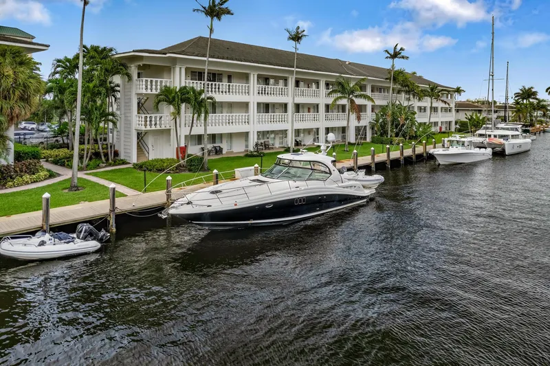  Yacht Photos Pics 2008 Sea Ray 44 Sundancer yacht docked by waterfront building with palm trees.