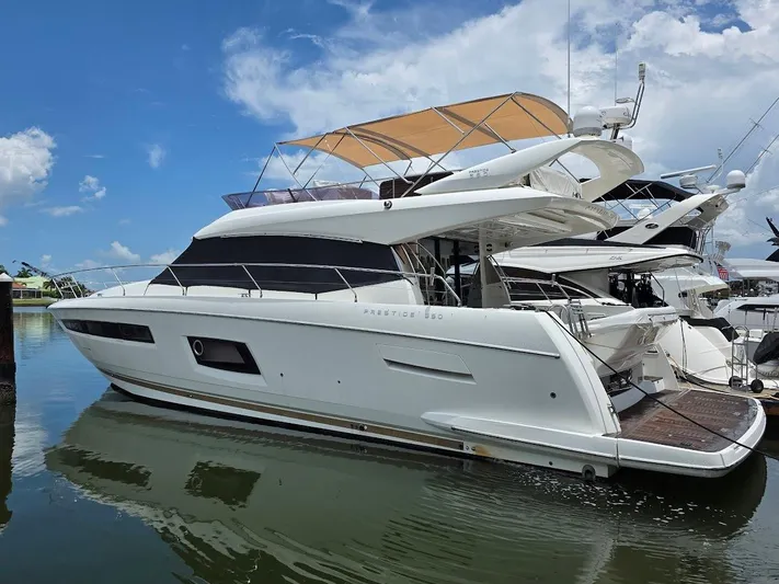 Just Peachy Yacht Photos Pics 2015 Prestige 550 Fly yacht docked, featuring sleek design and spacious flybridge under a blue sky.