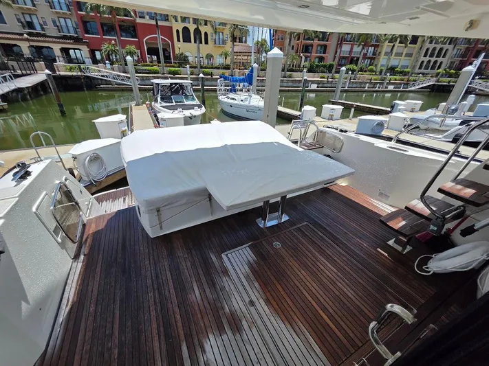 Just Peachy Yacht Photos Pics Prestige 550 Fly 2015 yacht deck with covered seating, docked in a marina.