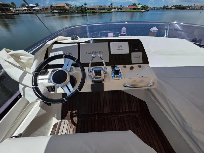 Just Peachy Yacht Photos Pics Helm of 2015 Prestige 550 Fly yacht with Garmin navigation, overlooking serene waterfront.