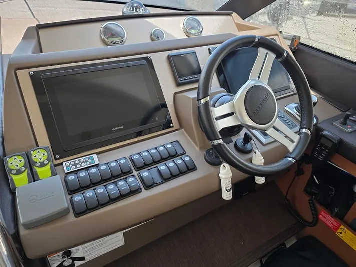 Just Peachy Yacht Photos Pics Control panel of a 2015 Prestige 550 Fly yacht with steering wheel and navigation screens.