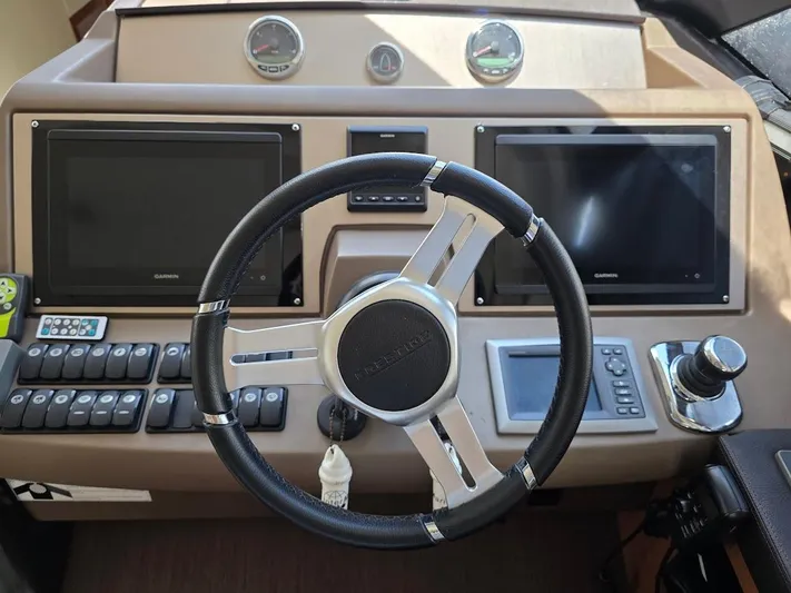 Just Peachy Yacht Photos Pics Steering console of 2015 Prestige 550 Fly yacht with dual Garmin displays.