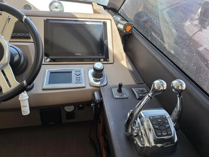Just Peachy Yacht Photos Pics Control panel of a 2015 Prestige 550 Fly yacht with steering wheel and navigation equipment.