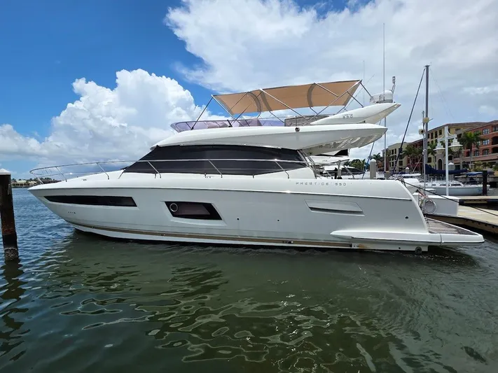 Just Peachy Yacht Photos Pics 2015 Prestige 550 Fly yacht docked in marina under blue sky.