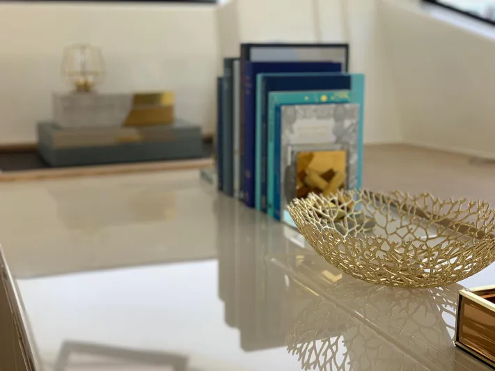 Charis Yacht Photos Pics Luxurious interior of 2020 Aquila 44 Yacht with decorative books and elegant gold bowl.