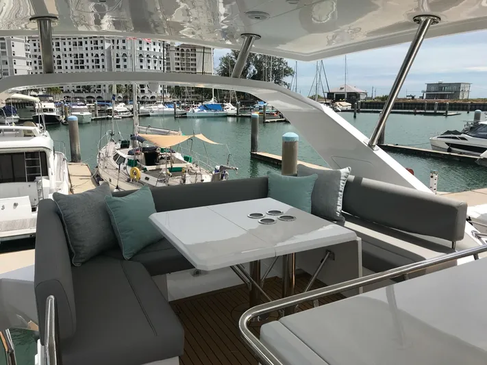 Charis Yacht Photos Pics Luxurious seating area on 2020 Aquila 44 Yacht, docked at a marina.