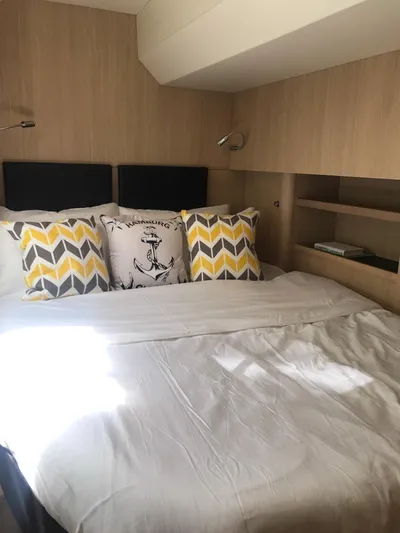 Charis Yacht Photos Pics Cozy bedroom in 2020 Aquila 44 Yacht with decorative pillows and wooden shelves.