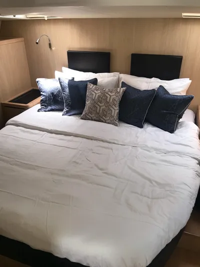 Charis Yacht Photos Pics Luxurious bedroom interior of 2020 Aquila 44 Yacht with plush bedding and decorative pillows.