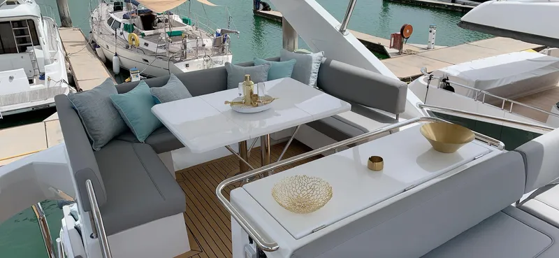 Charis Yacht Photos Pics Luxurious seating area on 2020 Aquila 44 Yacht, featuring elegant decor and marina view.