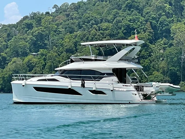 Charis Yacht Photos Pics Aquila 44 Yacht 2020 cruising on serene waters with lush green forest backdrop.