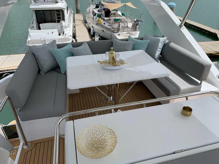 Charis Yacht Photos Pics Luxurious seating area on 2020 Aquila 44 Yacht with elegant decor and marina view.