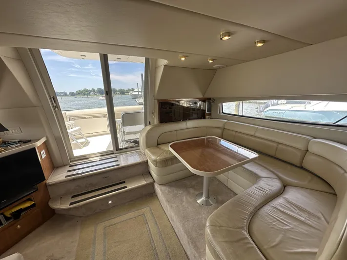  Yacht Photos Pics Luxurious 2002 Regal 3880 yacht interior with leather seating and wooden table, overlooking serene waters.